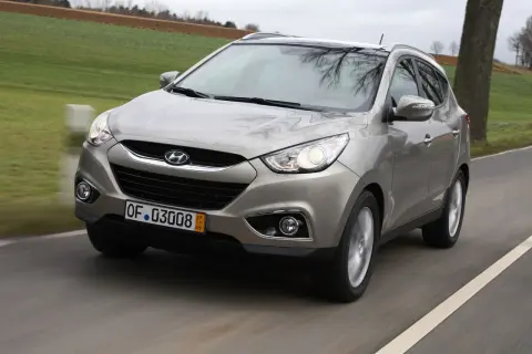 Szary Hyundai ix35 w ruchu drogowym, przód samochodu.
