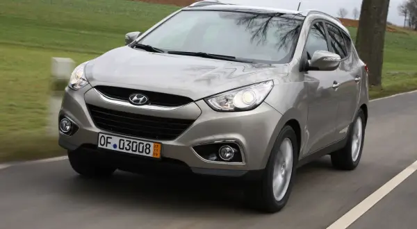 Szary Hyundai ix35 w ruchu drogowym, przód samochodu.